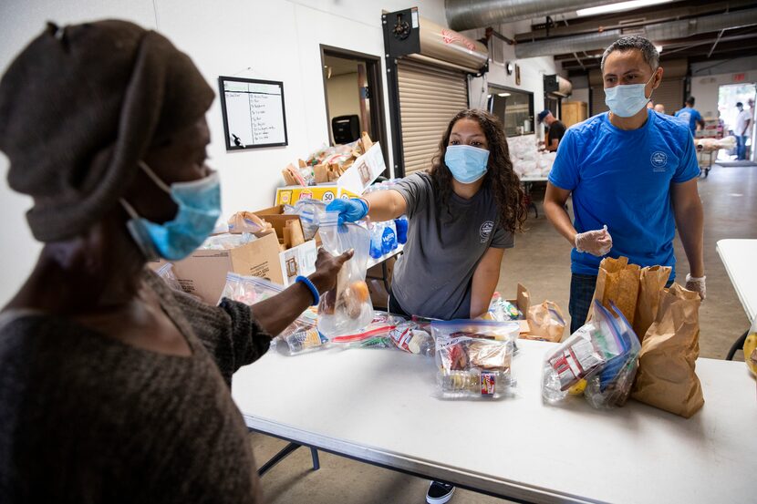 Rham Sandoval and his daughter, Zahira Sandoval (center), distribute food to those in need...