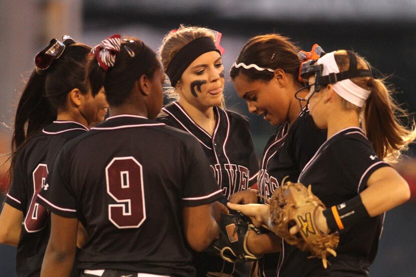 In a show of support, Mansfield Timberview infielders surround and encourage pitcher Mariah...