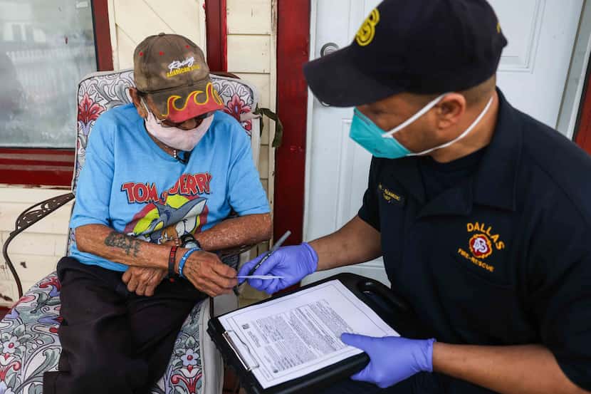 Corey Nix, paramédico de Dallas Fire Rescue entrega a Albert Garza, de 75 años, su cartilla...
