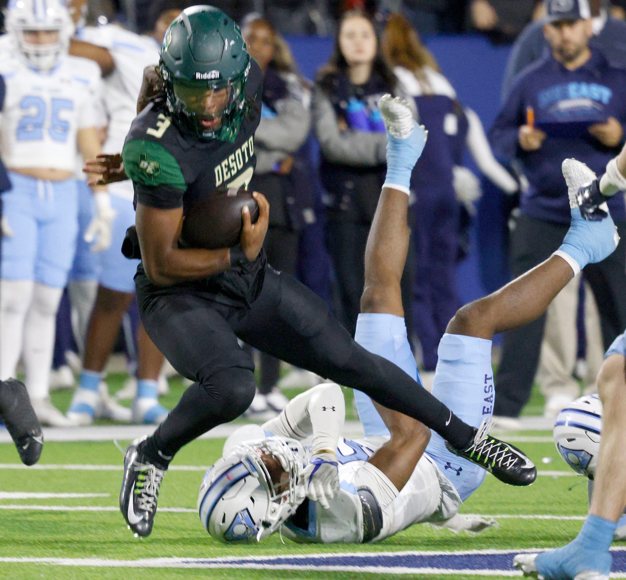 DeSoto's quarterback Kelden Ryan (3) jumps over Wylie East's Rome Jeffers (5) as he carries...