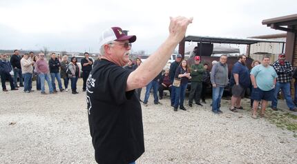 Troy Choate informs customers lining up outside Flores Barbecue how the serving lines and...