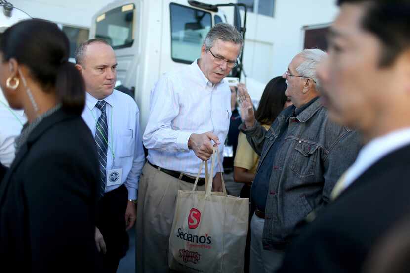 MIAMI, FL - DECEMBER 17:  Former Florida Governor Jeb Bush hands out items for Holiday Food...