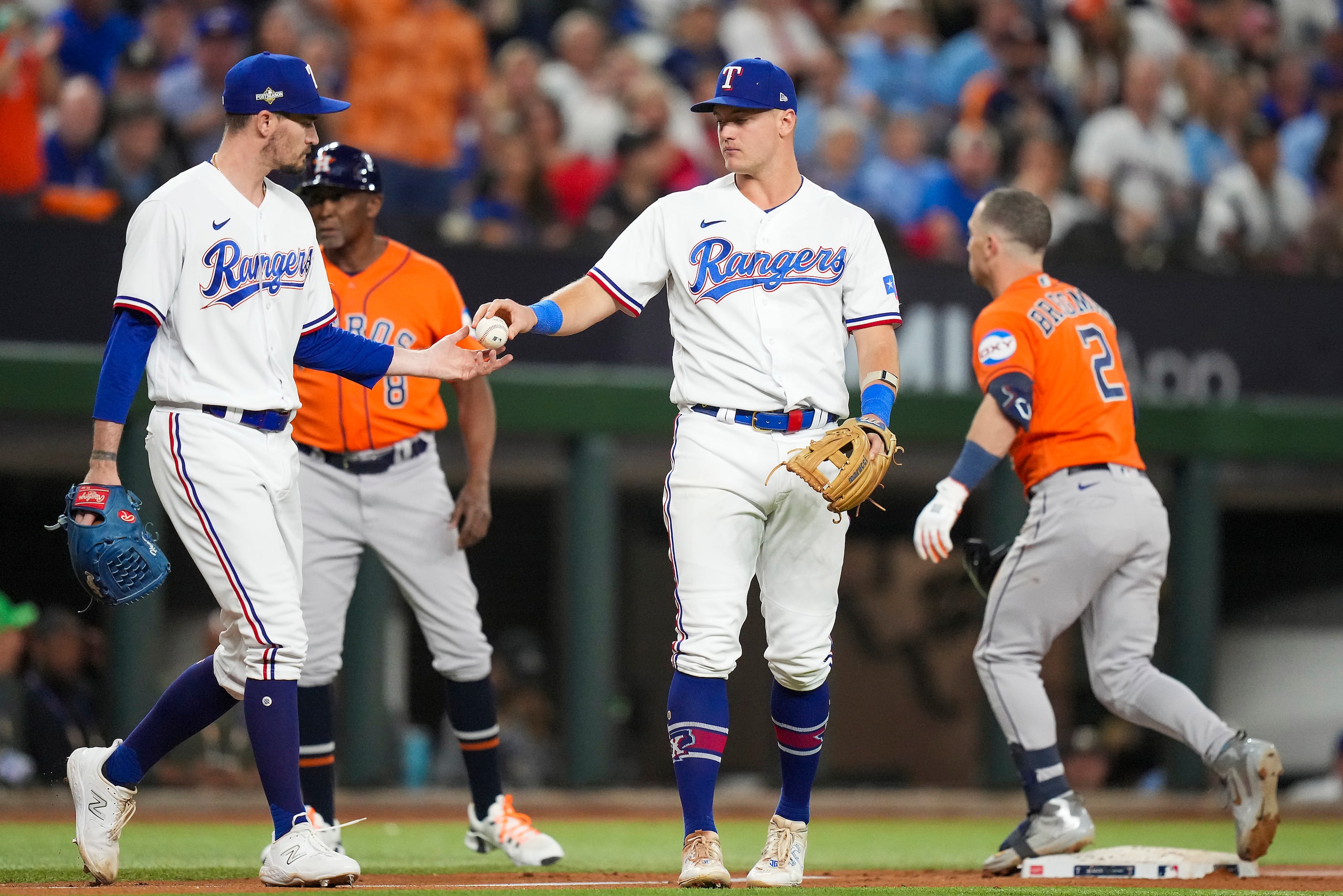 Texas Rangers third baseman Josh Jung hands the ball to pitcher Andrew Heaney after a triple...