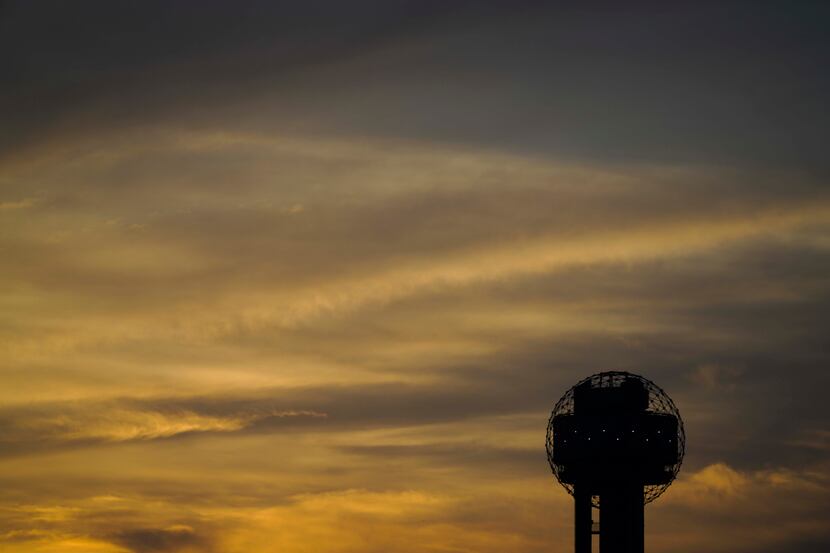 The sun set behind Reunion Tower on June 30, 2020, when dissipating Saharan dust passing...