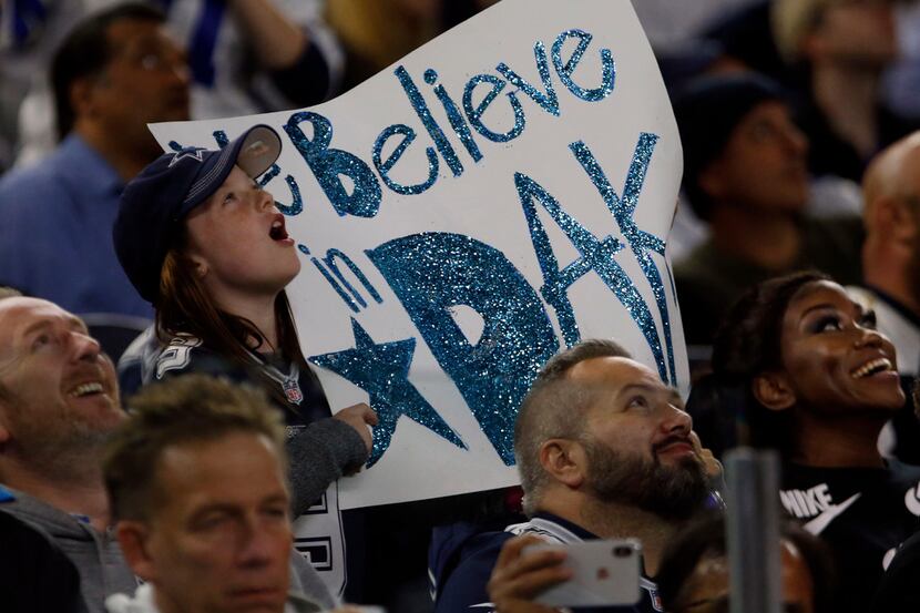A young fan helps up a "We Believe in Dak" sign during the second half of a NFL football...