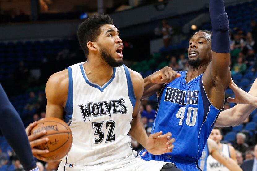Minnesota Timberwolves' Karl-Anthony Towns, left, eyes the basket as he drives around Dallas...