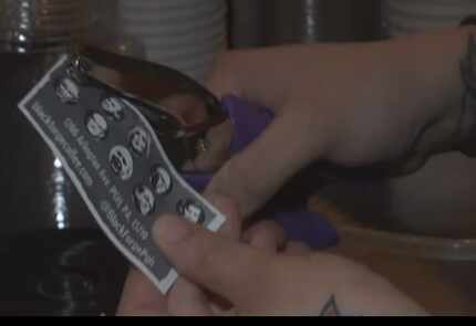 Black Forge co-owner Ashley Corts punches a hole in a sample card.