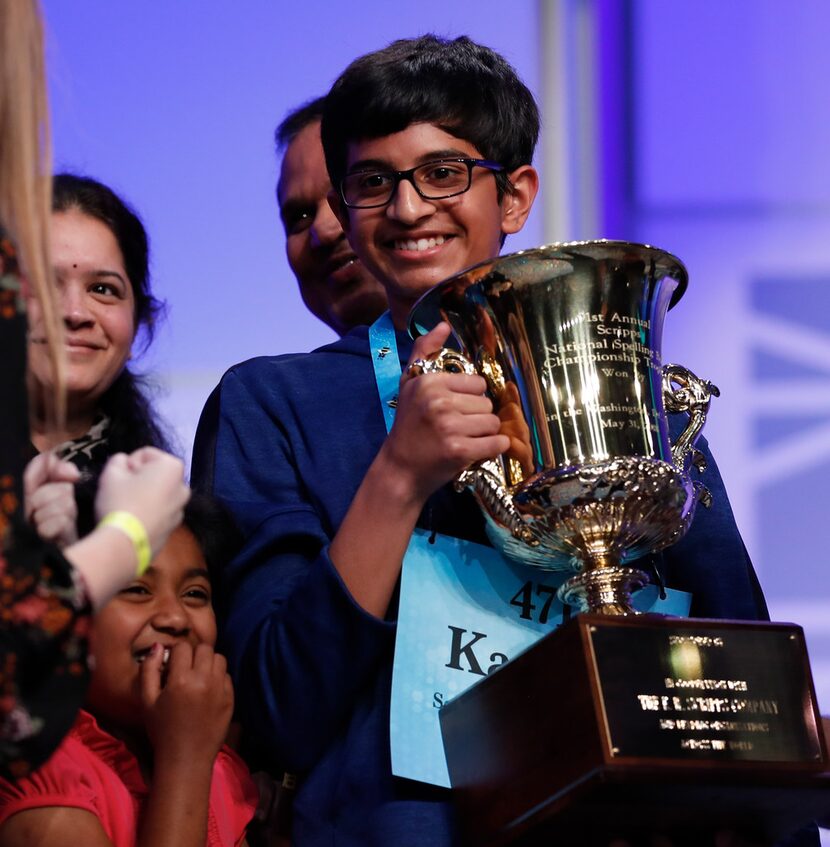 A jubilant Karthik Nemmani holds the Scripps National Spelling Bee Championship Trophy after...