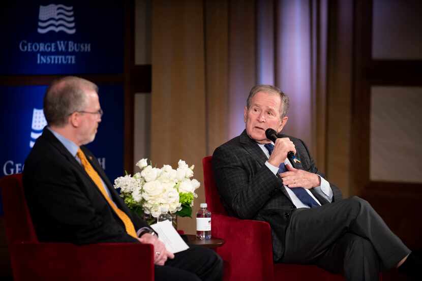 Former President George W. Bush speaks with David Kramer, the Executive Director of the...