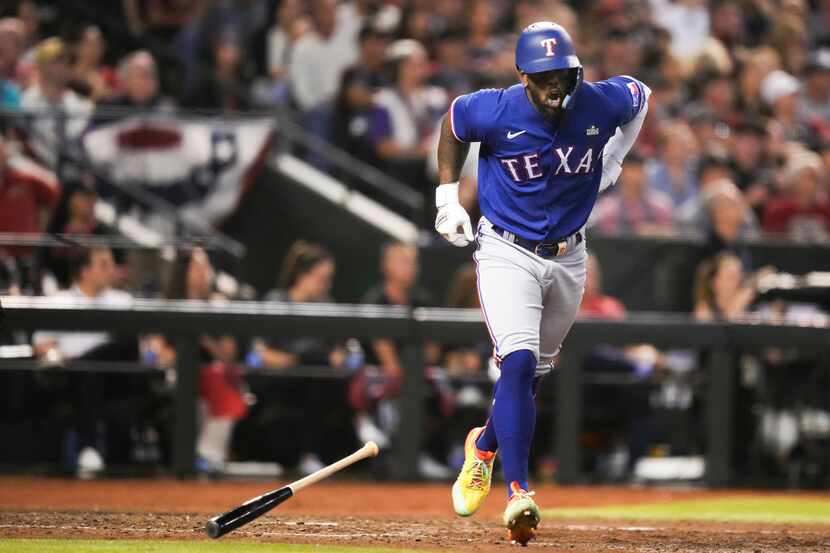 Texas Rangers’ Adolis Garcia grabs his left side after flying out in the eighth inning...