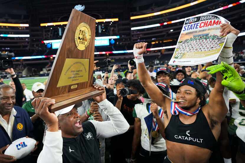 DeSoto football coach Claude Mathis lifts the championship trophy after a victory over...