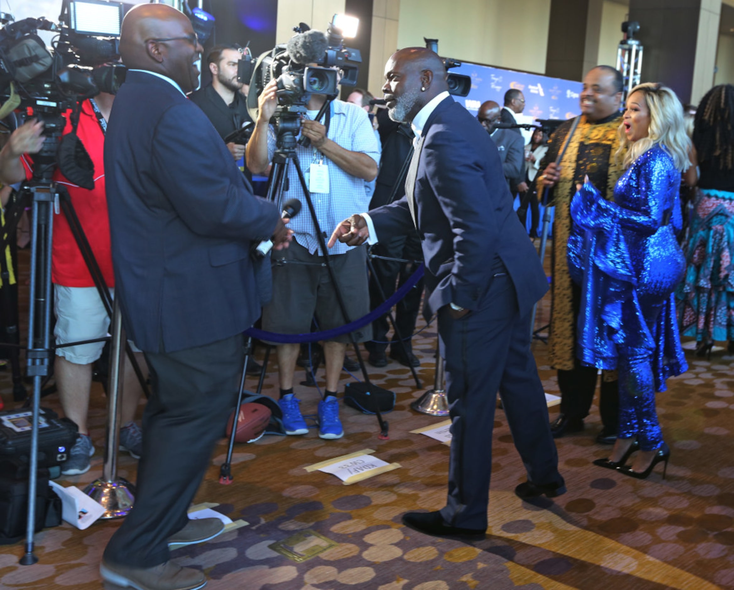 Emmitt Smith jokes with local broadcaster Newy Scruggs during the red carpet walk at the 8th...