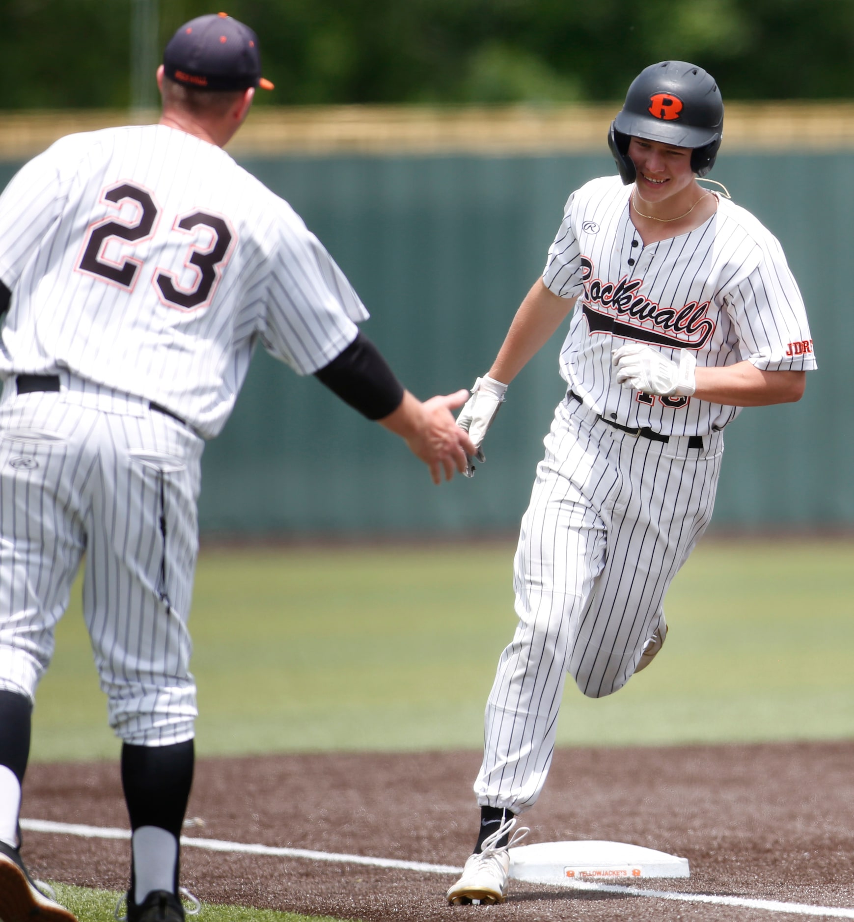 Rockwall outfielder Barrett Riebock (10) receives congratulations from head coach Barry Rose...