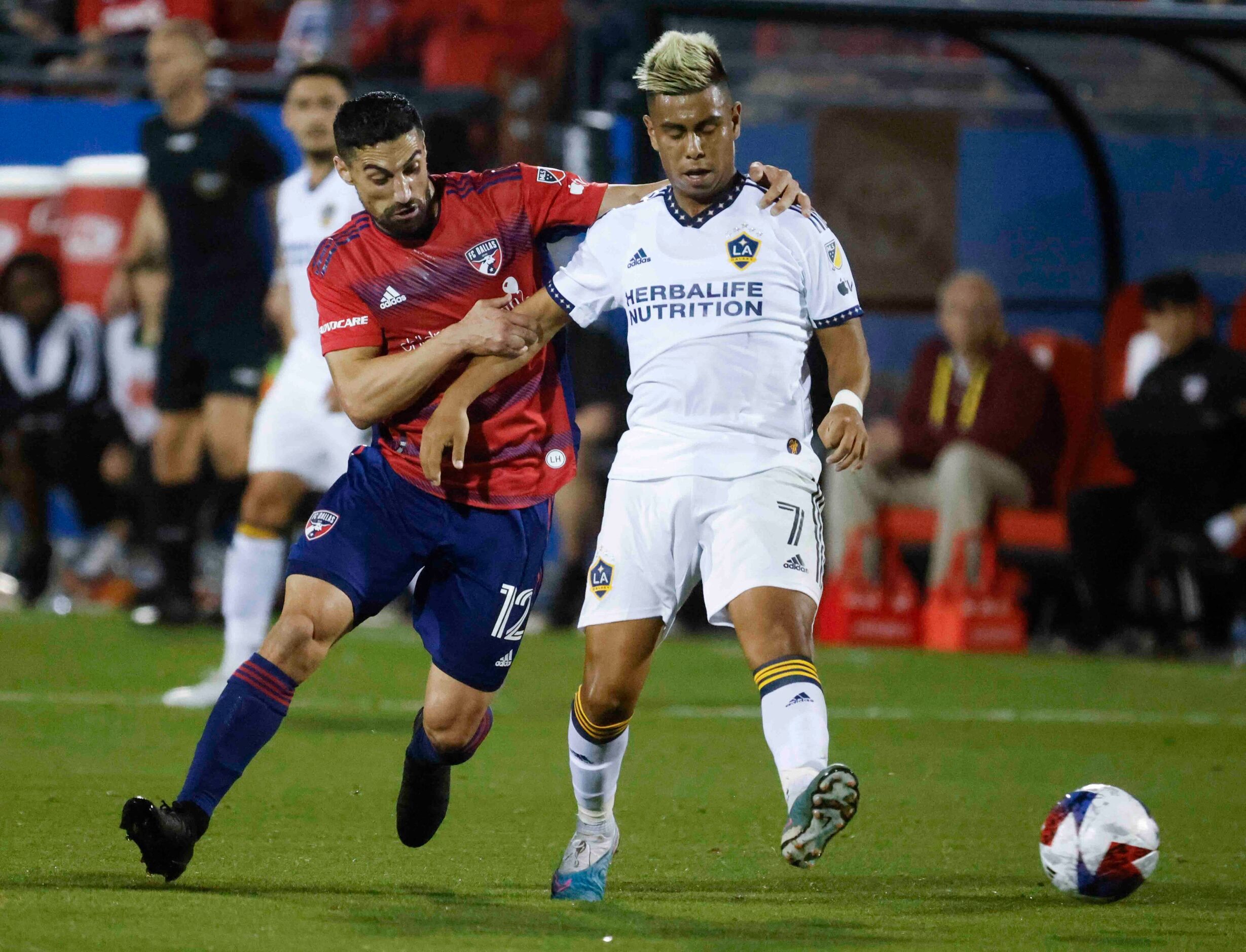 FC Dallas midfielder Sebastian Lletget (left) charges LA Galaxy midfielder Efrain Alvarez...