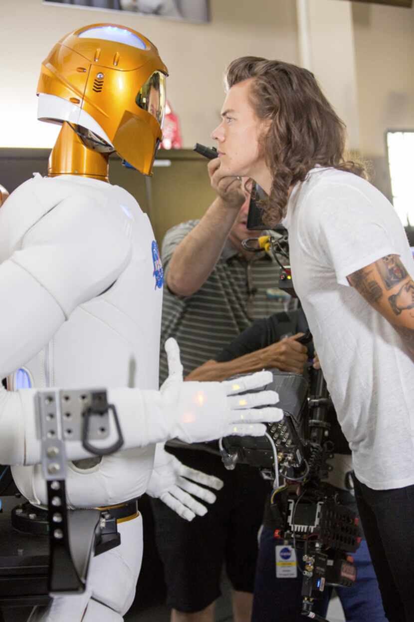 That's Robonaut, on the left, having a staring contest with One Direction's Harry Styles.