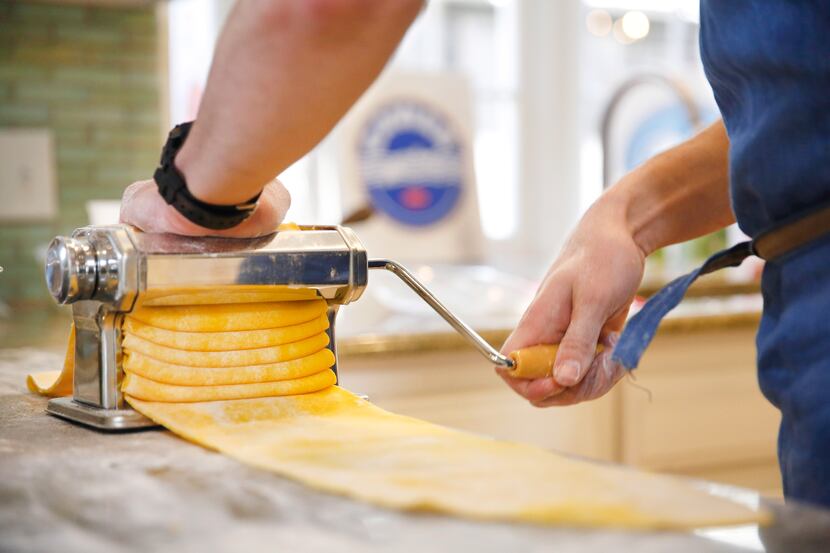 Restaurant owner and chef Julian Barsotti uses a pasta machine to thin the lasagna sheets...