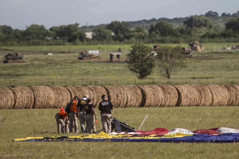 Investigators work in the pasture where the balloon crashed, killing 16 people.