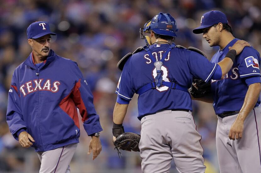 Texas Rangers pitching coach Mike Maddux talks to catcher Geovany Soto and starting pitcher...
