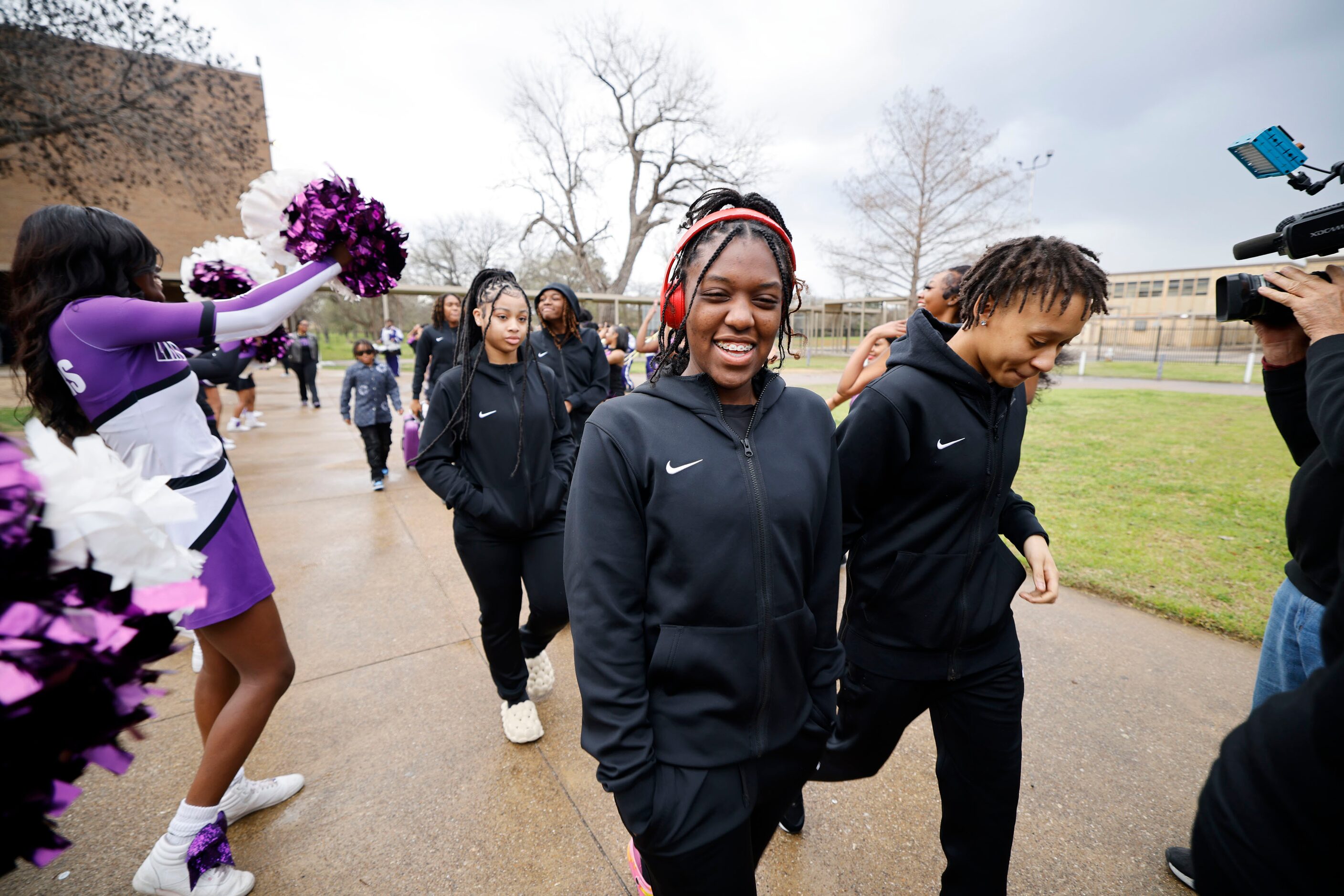 Lincoln High School basketball player Jalynn Staten, center, and her teammates walk to a bus...