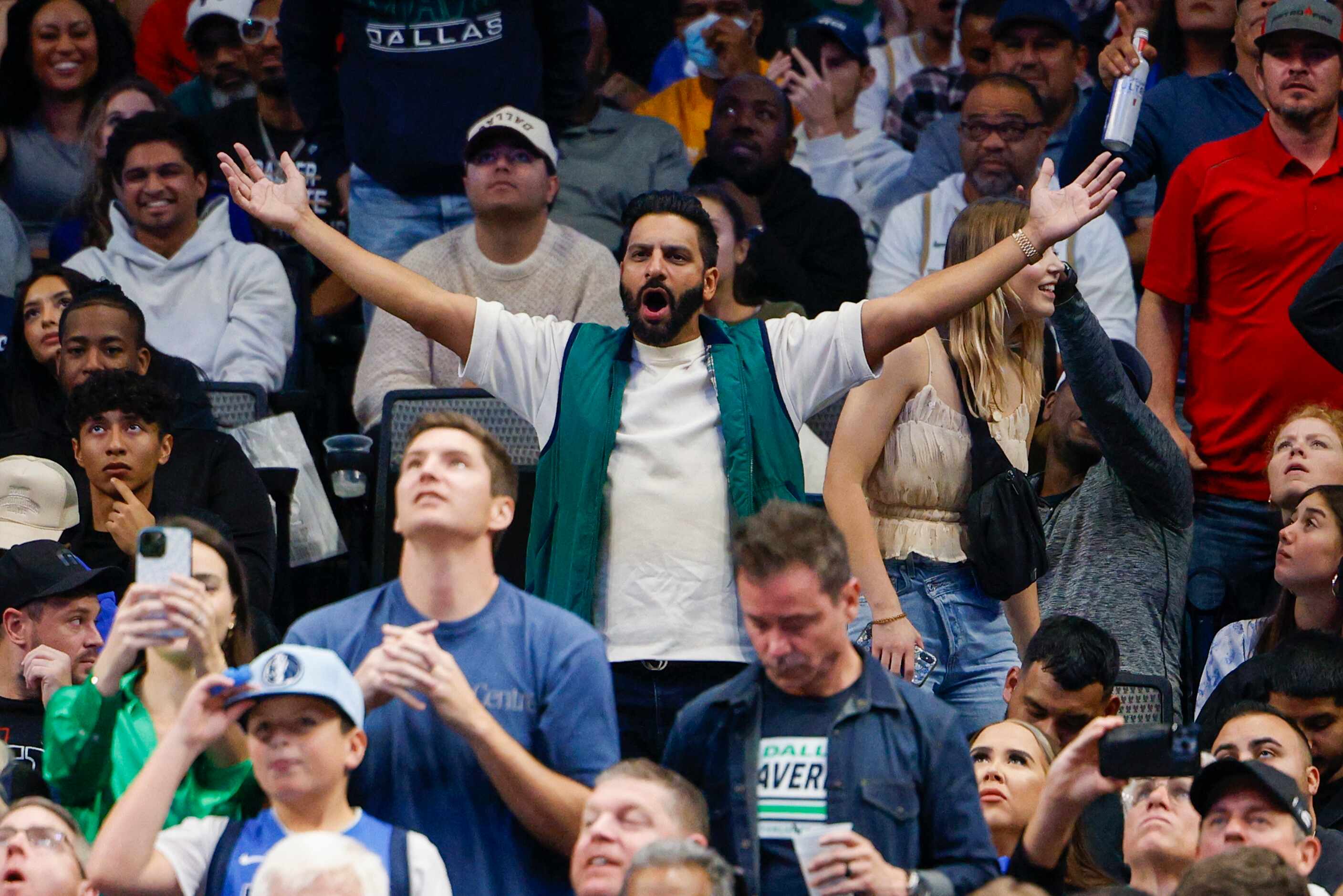 Fans react after a foul during the second half of an NBA game between the Dallas Mavericks...