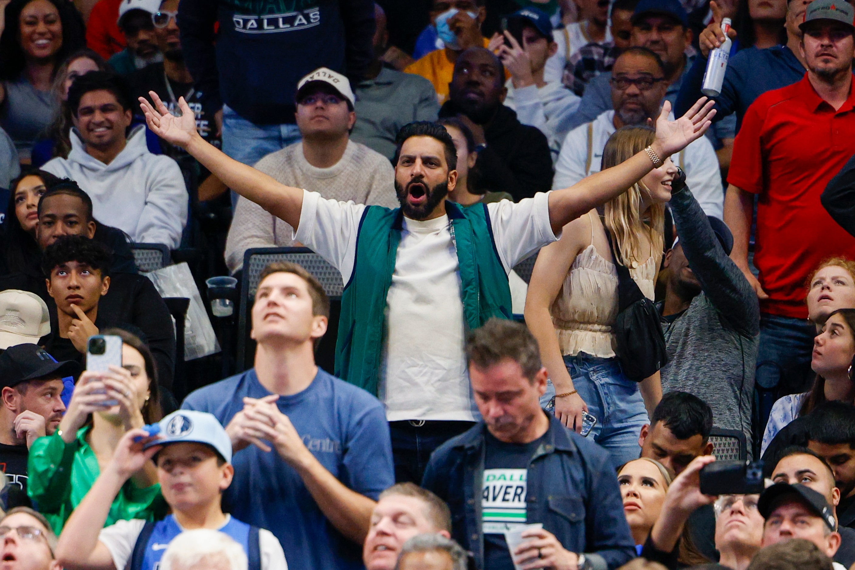 Fans react after a foul during the second half of an NBA game between the Dallas Mavericks...