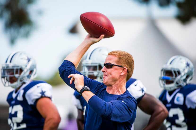 Dallas Cowboys head coach Jason Garrett throws a pass during drills at training camp on...