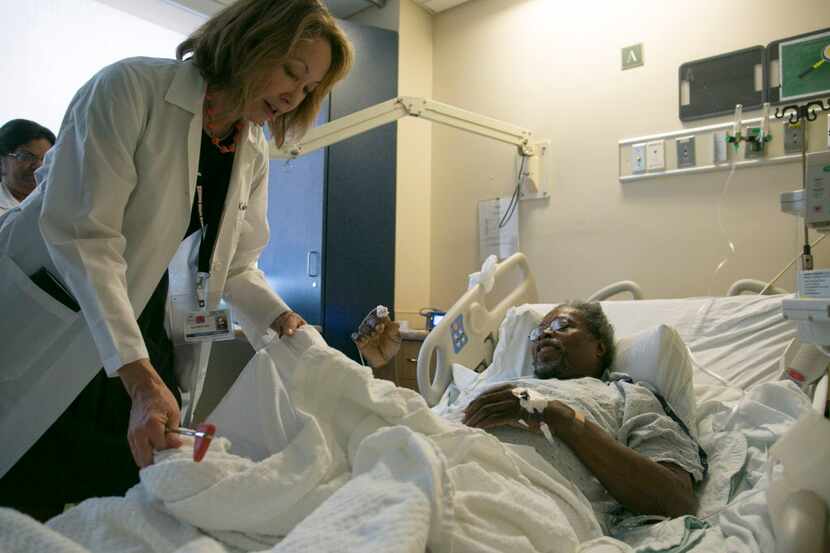 A neurosurgeon visits with a patient at Kings County Hospital Center in New York.