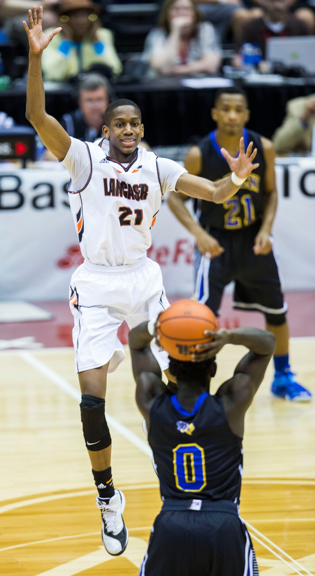 Lancaster guard/forward Brandon Moore (21) defends against Beaumont Ozen guard Jordan Hunter...