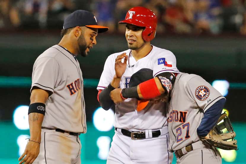 Texas catcher Robinson Chirinos playfully grabs Houston second baseman Jose Altuve as...