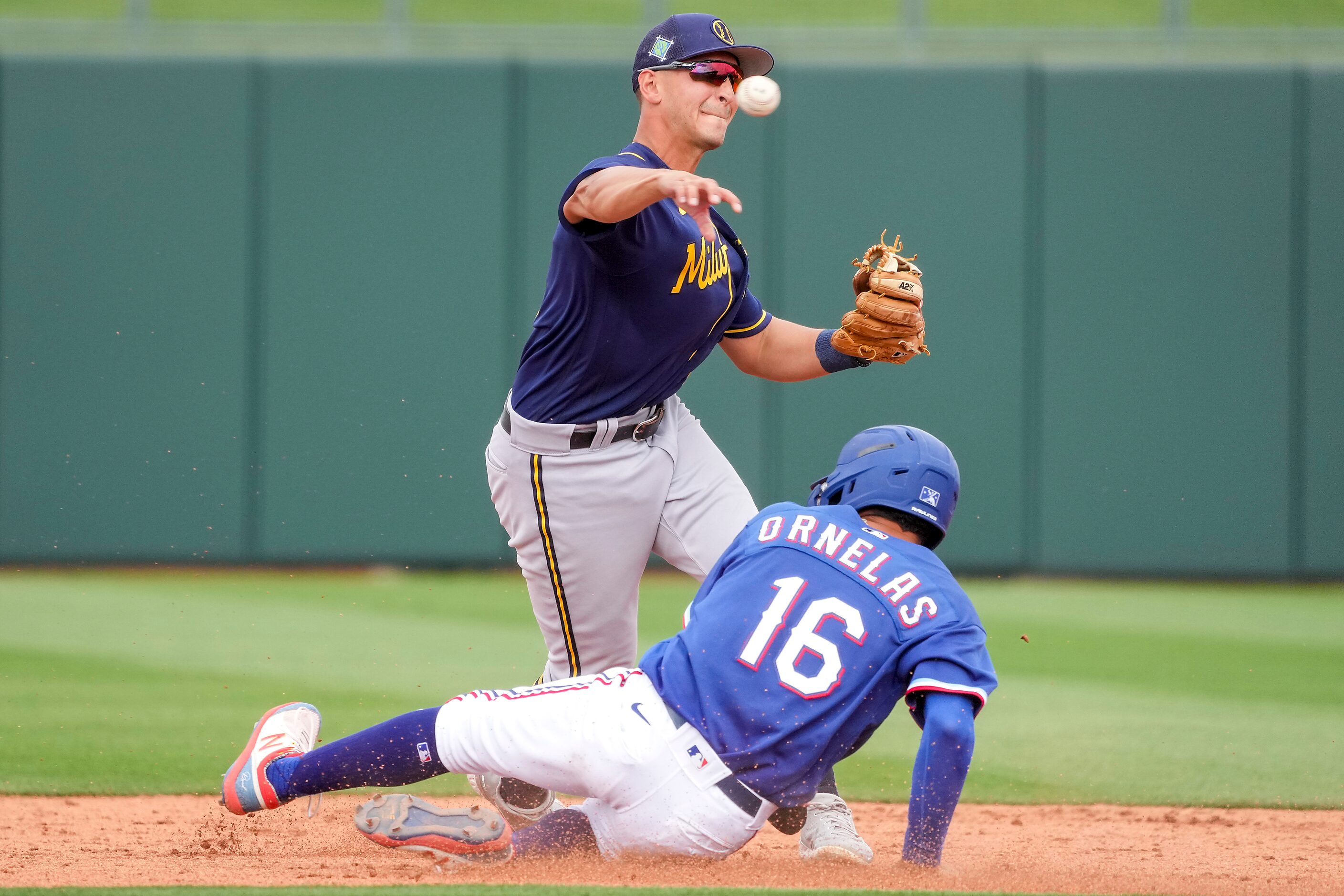 Milwaukee Brewers shortstop Brice Turang makes the relay as Texas Rangers infielder Jonathan...