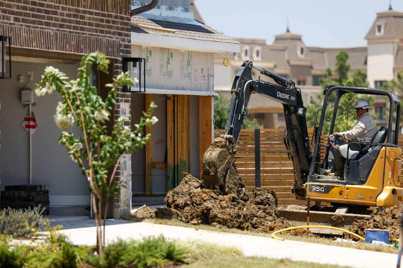 A construction worker digs into the front yard of a new home in the Parker Place...