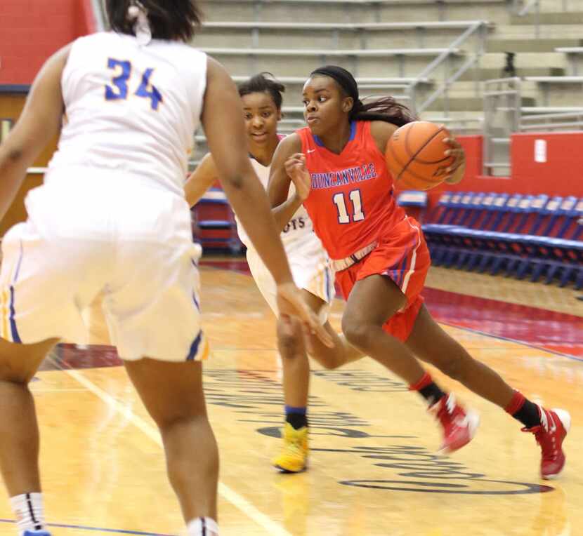 Duncanville guard Chrineisha Davis (11) drives to the basket between two Garland Lakeview...