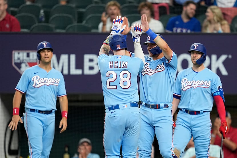 Texas Rangers' Jonah Heim (28) celebrates with Josh Jung, center right, Nathaniel Lowe,...