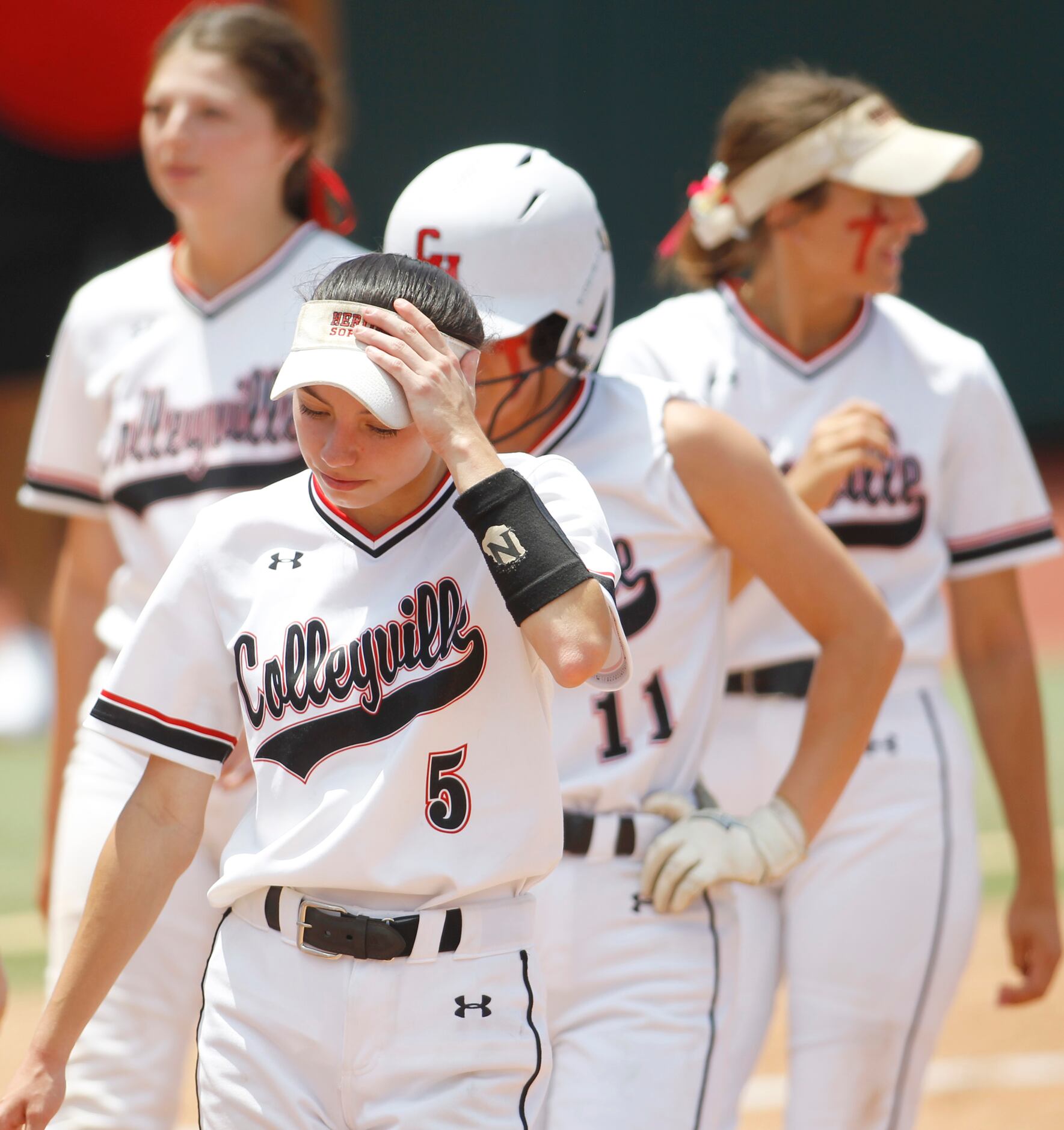 Colleyville Heritage outfielder Leah Perales (5) and teammates leave the field following...