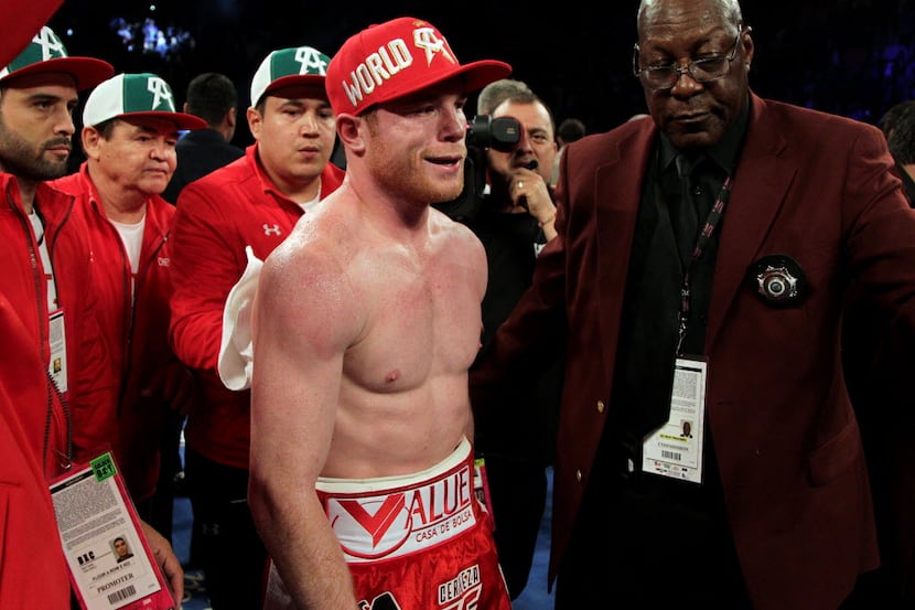 (FILES) This file photo taken on May 8, 2016 shows Saul Canelo Alvarez (C) of Mexico as he...