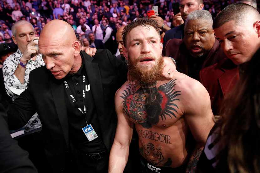 Conor McGregor is escorted from the cage area after fighting Khabib Nurmagomedov in a...
