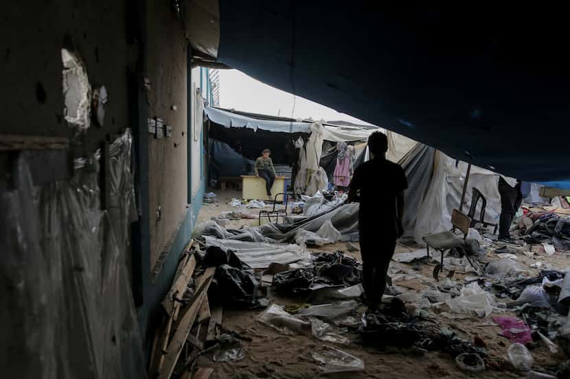 Palestinos desplazados inspeccionan sus tiendas destruidas por un bombardeo israelí en un...