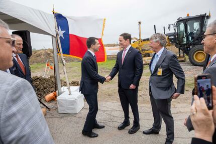 Pete Buttigieg (center left), U.S. Transportation Secretary, shakes hands with Dallas County...