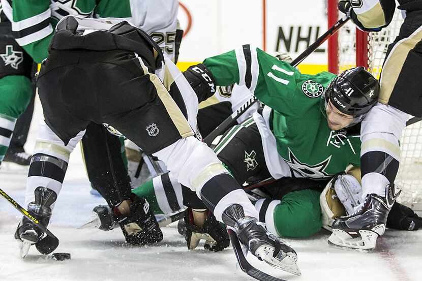 Dallas Stars left wing Curtis McKenzie (11) is tangled up in front of the Pittsburgh...