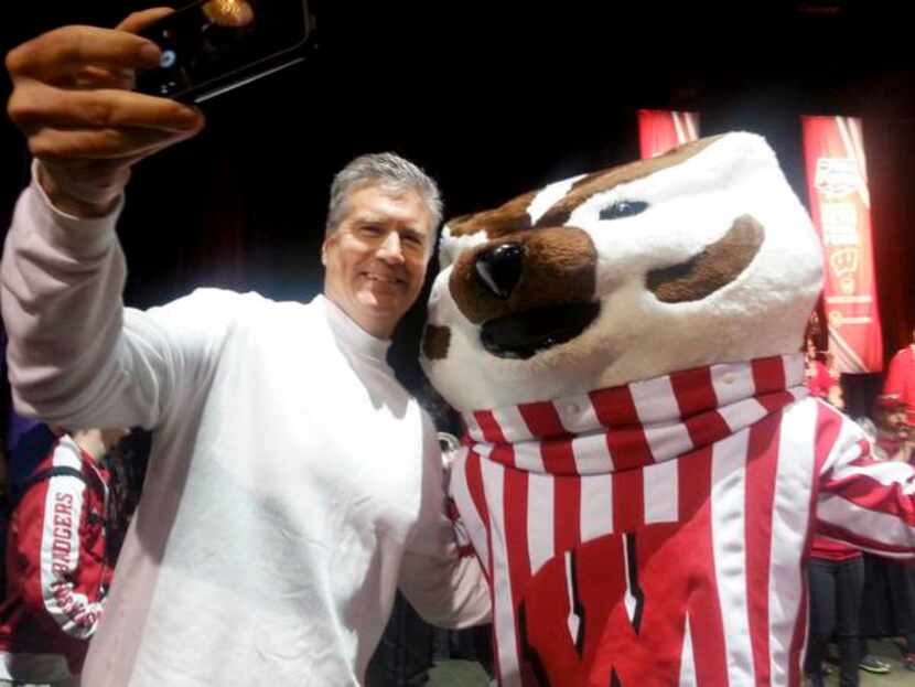 
Bucky Badger, mascot for the University of Wisconsin, stops for a photo with fan Dave...