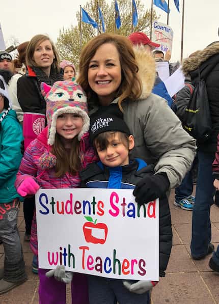 Amy Hardesty stands with one of her kindergarten students and a former kindergarten student...