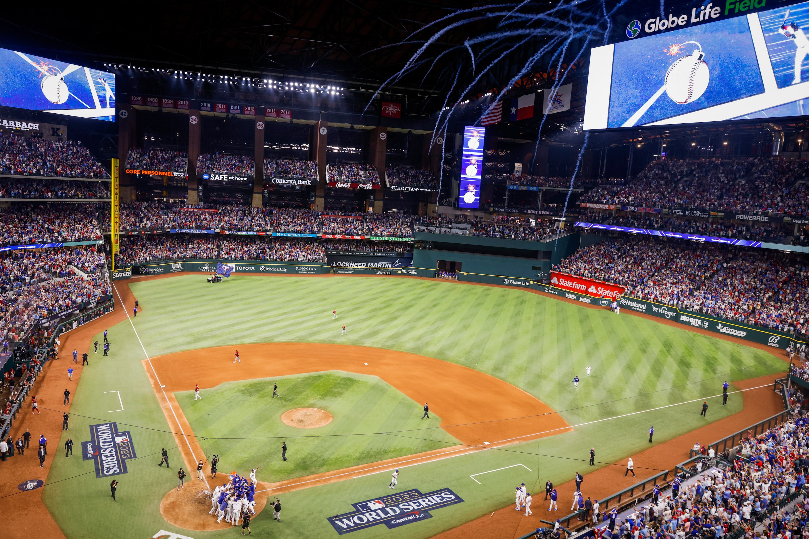 Fireworks explode as Texas Rangers right fielder Adolis Garcia is mobbed at home after...