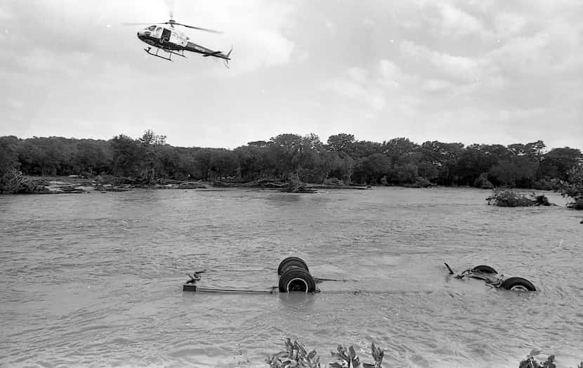 A helicopter hovers over the Seagoville Road Baptist Church bus swept away by floodwater on...