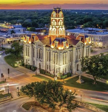 Aerial view of city courthouse lit up at dusk