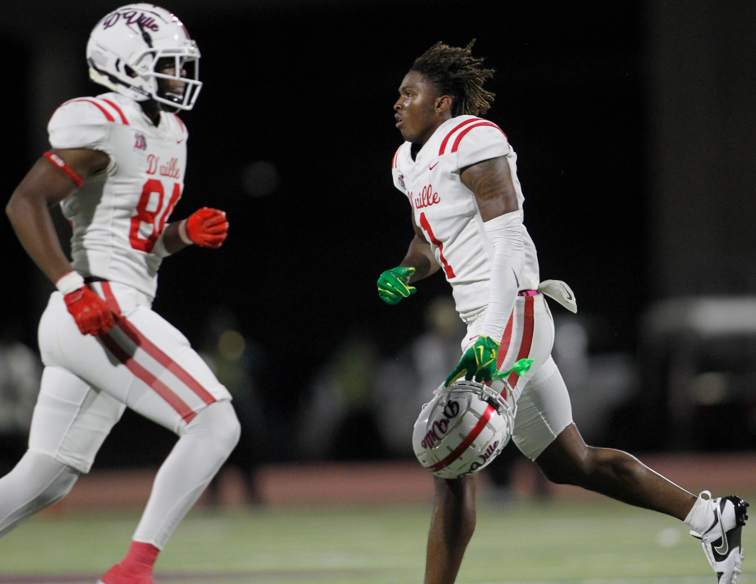 Duncanville receiver Dakorien Moore (1), right, runs off the field for a play after having...