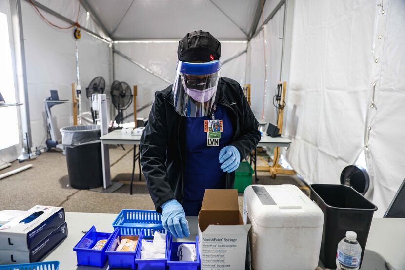 Nurse Lisa Wheeler starts the process to get a dose of the Pfizer-BioNTech COVID-19 vaccine...