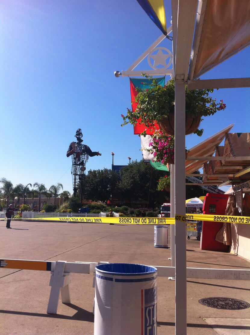 Barriers and fire line tape restrict access to the area around Big Tex after a fire burned...