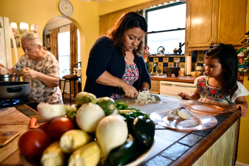 Chef Anastacia Quinones, 37, dices onion with her daughter Isabella Quinones, 4, as her...