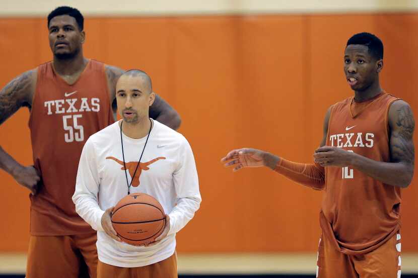 New Texas head basketball coach Shaka Smart, center, runs drills during a practice at the...