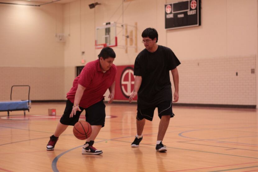 Teens play basketball in the Samuell-Grand recreation center gym, which received new...